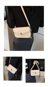 Detailed view of cream PU leather crossbody bag featuring a silver rotary lock and woven strap