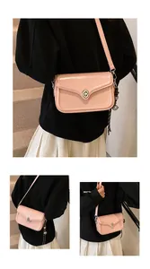 Three-way view of a pink glossy leather crossbody bag with metal lock and charm