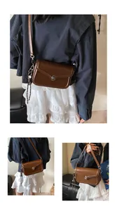 Detailed view of a brown vintage leather crossbody bag with silver oval twist lock