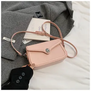 Detail of pink PU leather crossbody bag with silver twist lock and luxury texture
