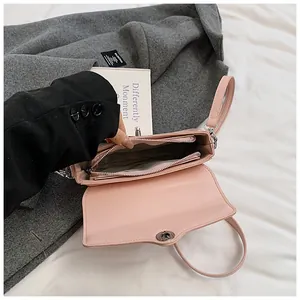 Detail view of pink leather crossbody bag interior with three compartments and silver hardware