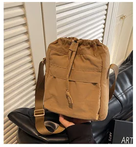 Détail macro du sac cordon en nylon kaki avec plis texturés et bandoulière réglable