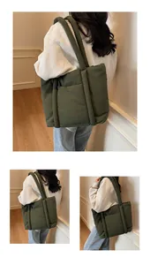 Makro-Detail der dunkelgrünen gesteppten Daunen-Shopper-Tasche mit gepolstertem Riemen
