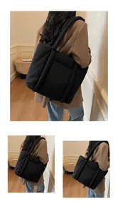 Detail der schwarzen Puffy-Tasche mit gepolstertem Griff und Struktur der Seitentasche