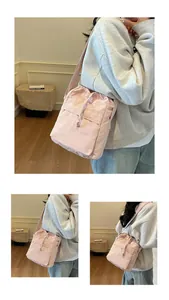 Gros plan du sac seau rose clair en nylon avec cordon de serrage et bandoulière large