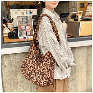 Close-up of high-capacity leopard print shoulder bag in a cozy cafe setting