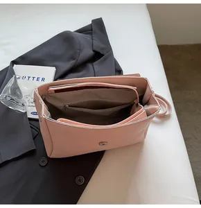 Detailed top view of the spacious pink handbag interior with multiple compartments and lining