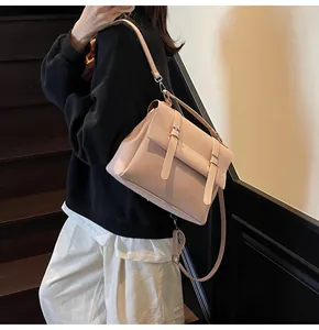 Fashionable pink PU leather backpack shown on person by wooden stairs in a modern style