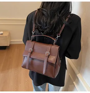 Brown vintage college style backpack showing the matte leather texture on model back