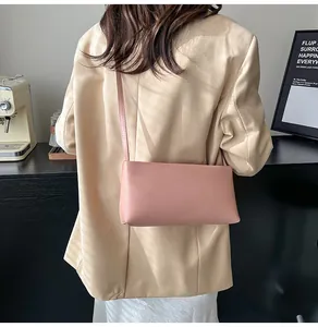 Lifestyle view of a minimalist pink baguette bag on a model for daily commute outfit