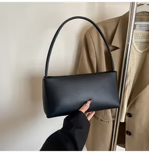 Detailed view of a black baguette shoulder bag in matte PU leather with smooth lines