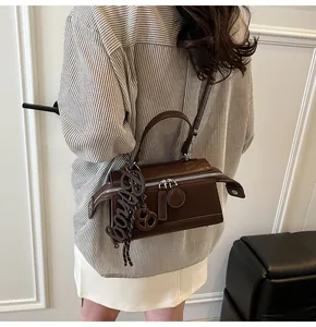 Detail of dark brown leather pillow bag with silver zippers and B-shaped charm