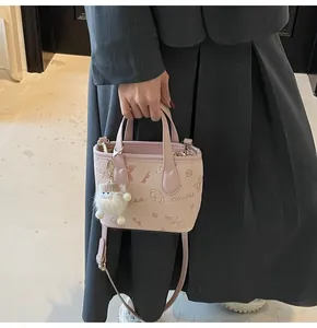 Detail van lichtroze tas met vlinderreliëf en een pluizige schaapvormige hanger