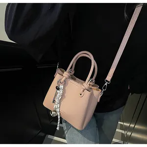 Detail view of pink lychee pattern bucket bag with silk scarf and bell charm