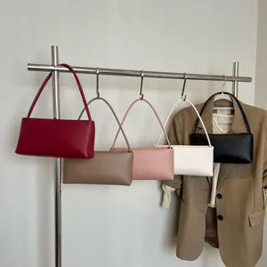 Minimalist baguette underarm bags in five colors hanging on a modern metal rack