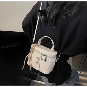 Detail of off-white cylindrical bucket bag with woven rope charm and BEIBEI tag