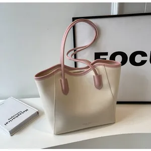 Detail of minimalist tote bag with color-block cream and pink faux leather finish