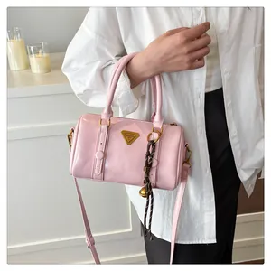 Pink glossy bowling bag detail with gold metal logo and brown bell charm on strap