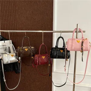 Retro bowling handbag in shiny finish with metallic logo and adjustable crossbody strap