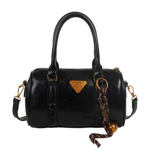 Glossy black bowling bag with double handles and golden triangular logo on white background
