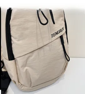 Detail der hellbeige Nylon-Brusttasche mit TENGRUN-Logo und schwarzem Reißverschluss