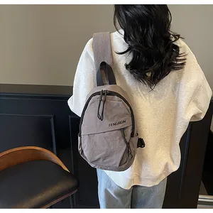 Detailansicht der grauen Nylon-Brusttasche mit verstellbarem Riemen am Modell getragen