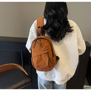 Detailansicht der braunen Nylon-Brusttasche mit TENGRUN-Logo und breitem Schultergurt