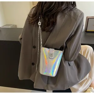 Detailed view of silver holographic bucket bag with metal chain strap and buckle closure