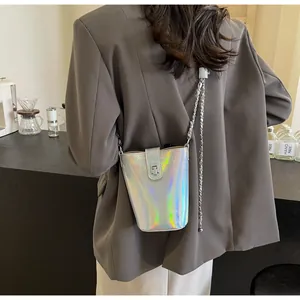 Detail of silver holographic bucket bag with metallic chain and turning lock closure