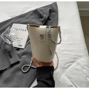 Detail of cream white bucket bag showing silver metal clasp and fine leather texture