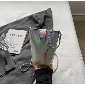 Detail view of iridescent silver bucket bag with metallic chain strap and twist lock