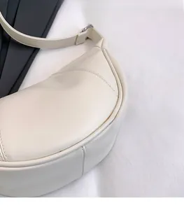 Detailaufnahme der cremeweißen Tasche mit glatter Kunstlederstruktur und feinen Nähten