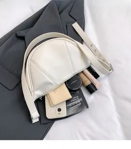 Detailansicht der cremefarbenen Halbmondtasche mit Ziernähten und breitem Schultergurt