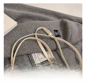 Detailed close-up of cream leather shoulder bag with silver chain and soft texture