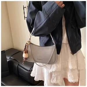 Detail of light grey retro underarm bag with chain strap and plush ice cream pendant