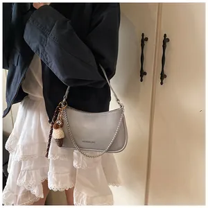 Detail of silver metallic underarm bag with chain strap and ice cream charm decoration