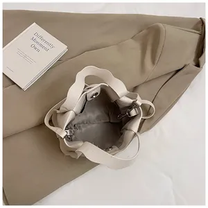 Schicke beige Eimertasche aus strukturiertem Leder mit Wellenkante und Magnetverschluss