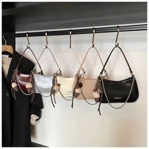 Detail view of colorful half-moon underarm bags with metal chains and charms