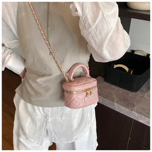 Pink quilted mini bag featuring pearl zipper detail and gold chain shoulder strap