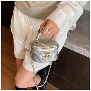 Detail of silver quilted mini crossbody bag with pearl pendants and chain strap
