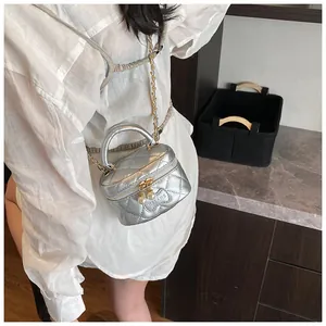 Detail of silver quilted vanity bag featuring pearl zipper charms and chain strap