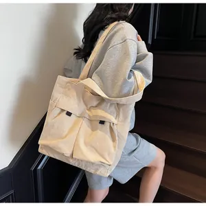 Detailed view of beige corduroy tote bag showing dual front pockets and texture on a model