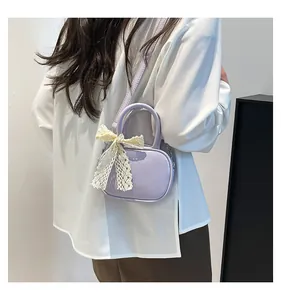Side view of lavender crossbody bag with lace bow on model against a white wall