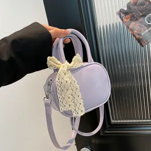Lavender faux leather handbag with lace bow detail and detachable strap shown in lifestyle set