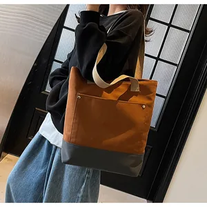 Detailed view of canvas tote bag featuring contrast stitching and reinforced base rivet