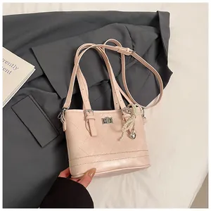 Close-up of pink quilted tote bag with pearl heart pendant and elegant metal lock detail