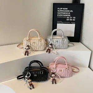 Bolsos Boston acolchados en cuatro colores con dijes de perlas y correas
