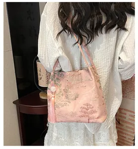 Detail of pink satin bucket bag with traditional Chinese landscape embroidery and silk tassels