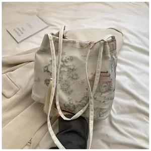 Detailed close-up of Chinese style embroidered crossbody bucket bag with elegant tassels