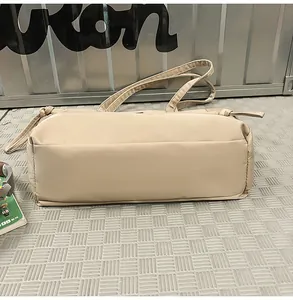 Dettaglio della borsa tote in nylon beige con nodi decorativi e cuciture resistenti
